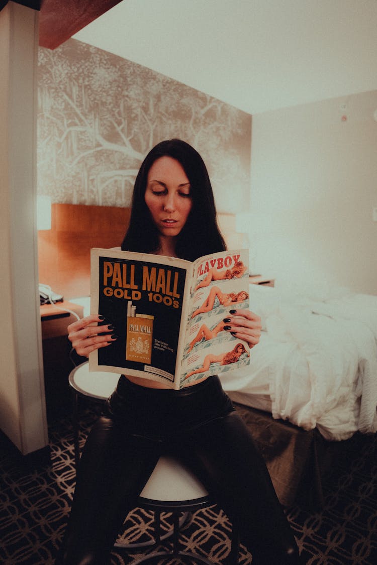 Woman Sitting And Reading A Magazine