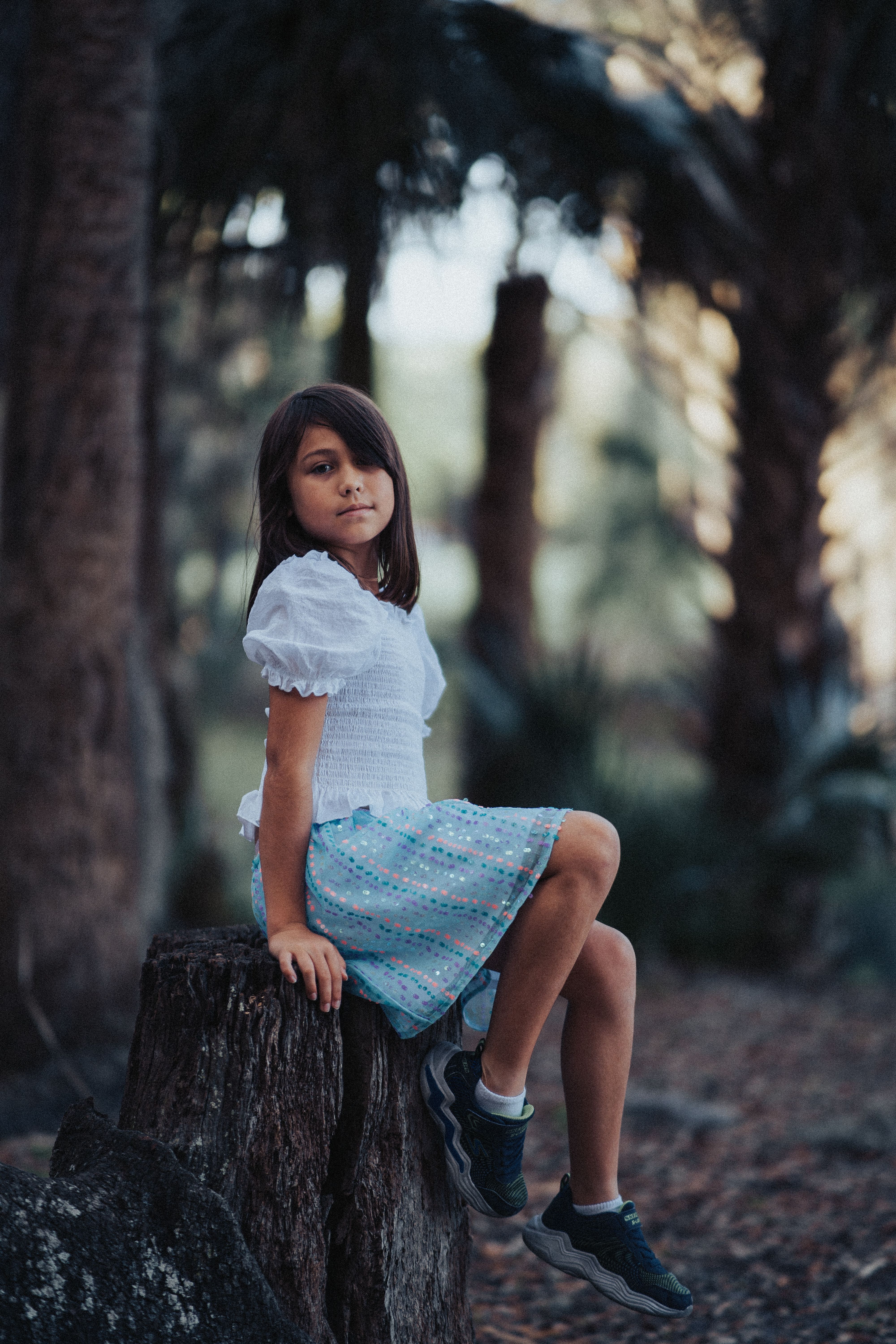 Young Girl Sitting on a Tree Stump in a Forest · Free Stock Photo