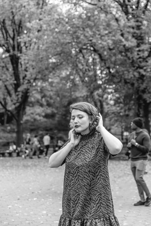 Woman Standing in a Park with her Eyes Closed