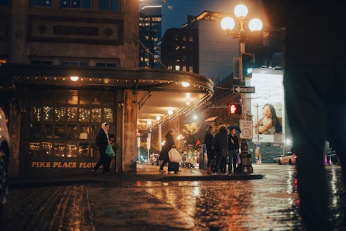 People Walking on Sidewalk During Night Time