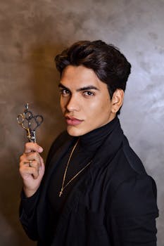 Young man with scissors in a stylish portrait, showcasing modern fashion.