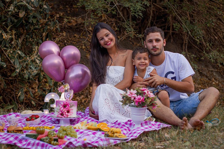 Beautiful Family Sitting On Picnic Blanket 