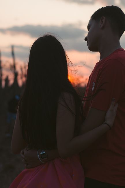 Fotomural Una pareja se abraza durante un hermoso atardecer al aire libre, creando una atmósfera romántica y serena.