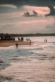 Serene beach scene at sunset in Paracuru, Brazil with people enjoying the ocean.