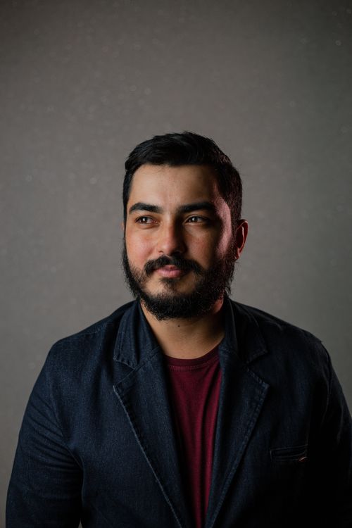 Free Studio portrait of a bearded man wearing a blazer, looking confident and thoughtful. Stock Photo