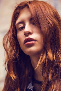 Close-up of a young woman with red hair, showcasing natural beauty and style.