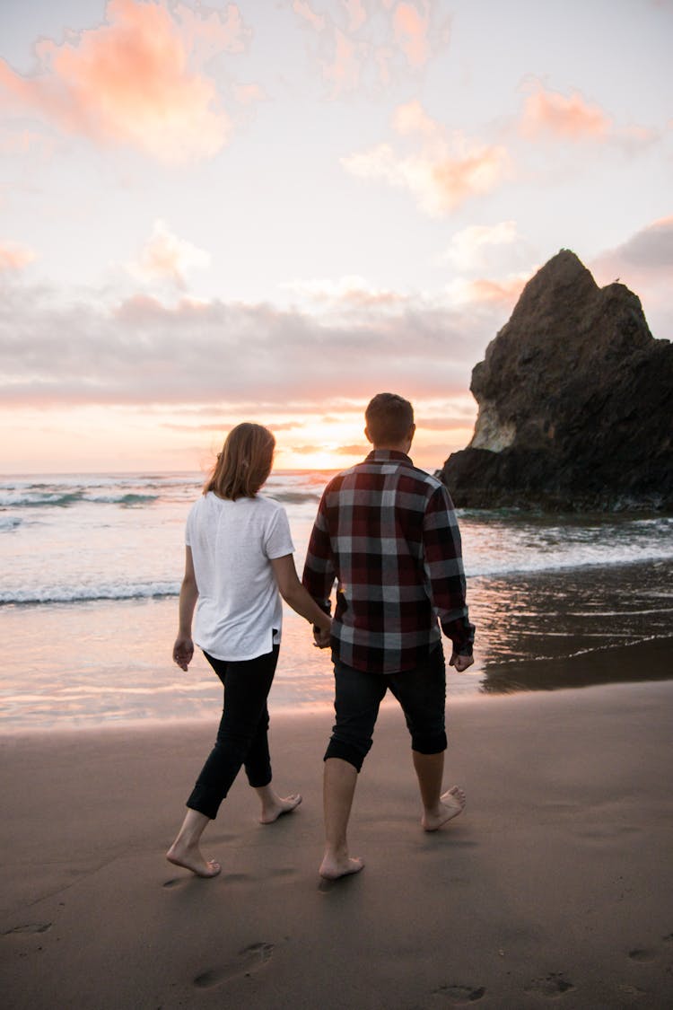 Two Man And Woman Walking While Holding Hands Together