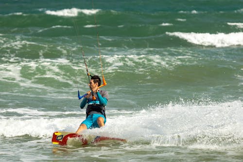 A Man in Blue Shorts Kitesurfing