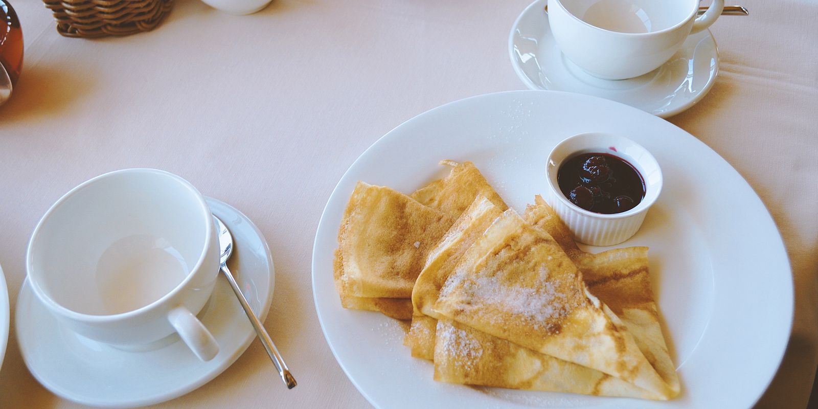 Crepes dusted with sugar served with tea on a morning table
