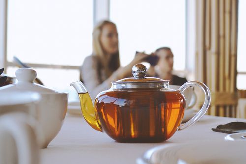 Free A warm close-up of a glass teapot with hot tea on a restaurant table during the day. Stock Photo