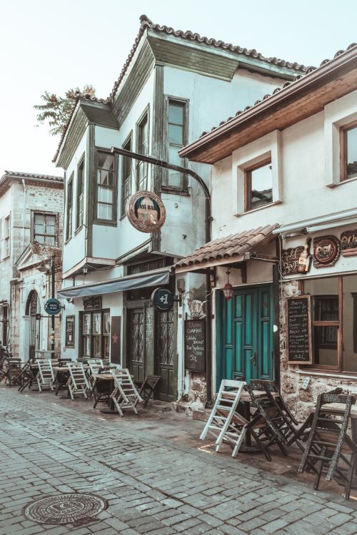 Free Quaint alley featuring vintage cafes and shops with outdoor seating, perfect for exploring history and culture. Stock Photo