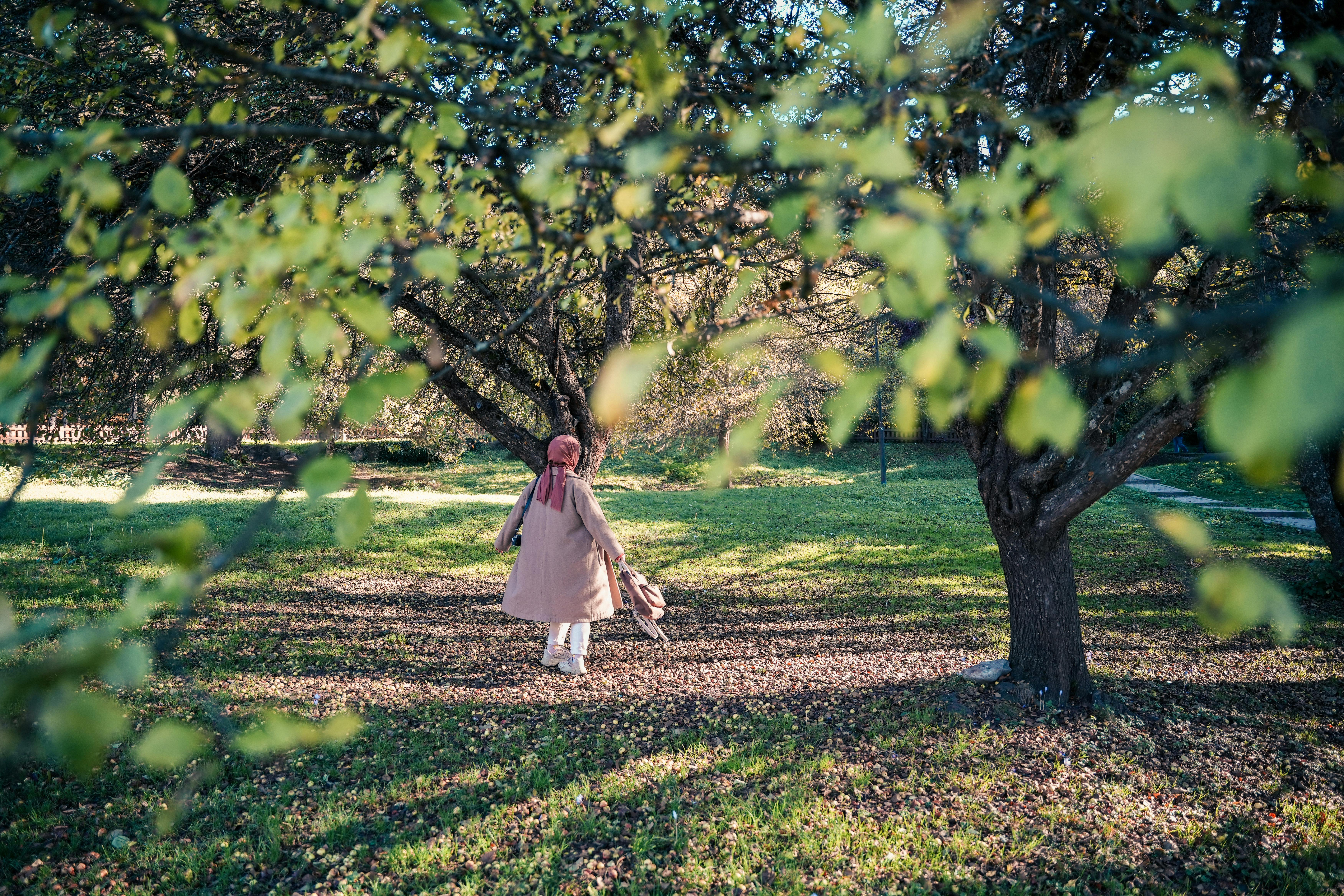 Free Girl in White Dress Standing on Green Grass Field Stock Photo