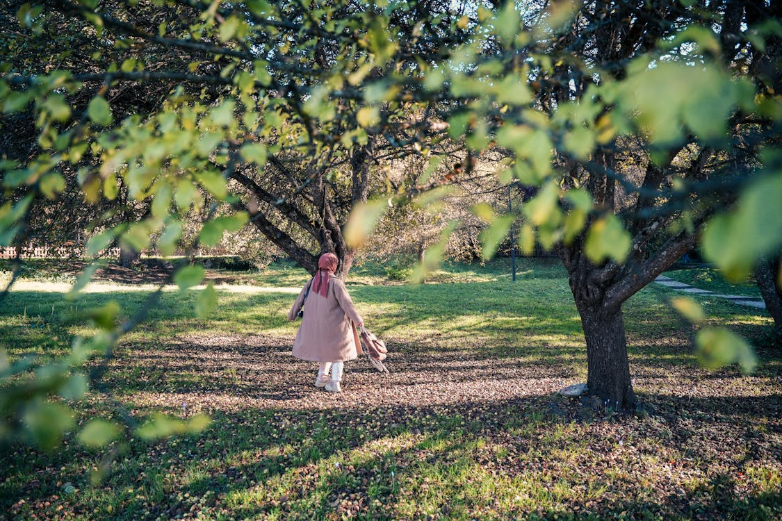 Free Girl in White Dress Standing on Green Grass Field Stock Photo