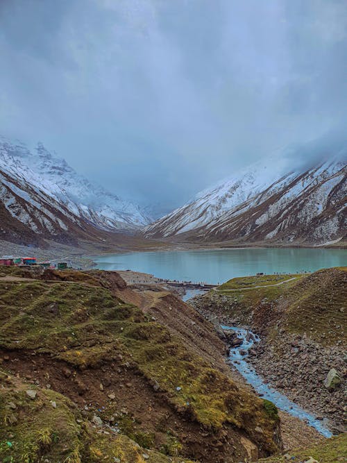 A Lake Surrounded by Mountains Covered with Snow