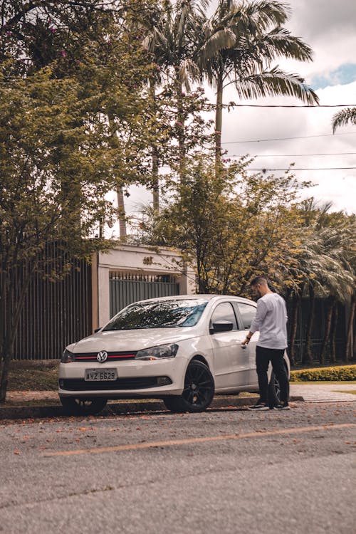 A Person Wearing a Gray Long Sleeves Opening a White Car