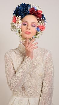 A stunning portrait of a bride in a floral headdress and lacy gown.