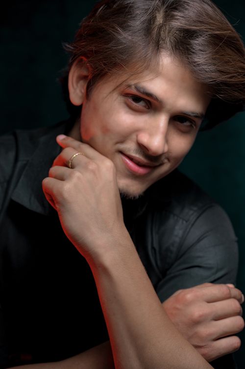 Free Portrait of a handsome South Asian man with a charming smile, taken indoors with artistic lighting. Stock Photo