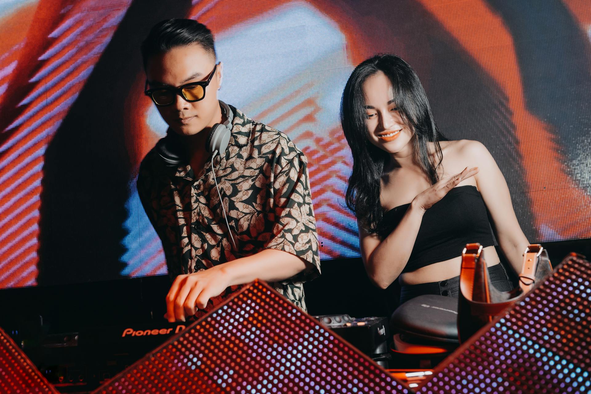 DJ mixing music with a dancer enjoying the vibes at a lively nightclub.