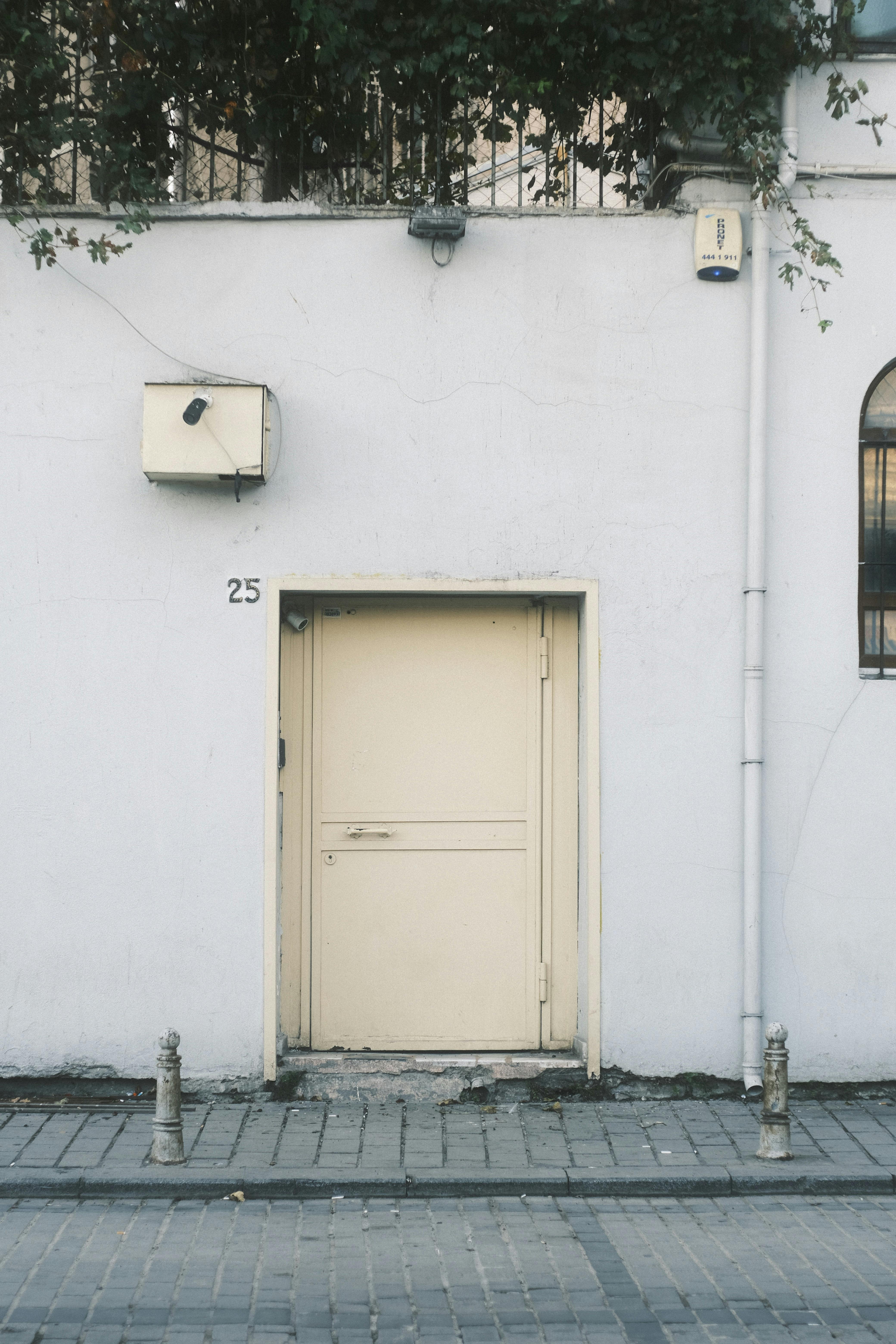 A simple urban doorway on a street with cobblestones offers a minimalist aesthetic.