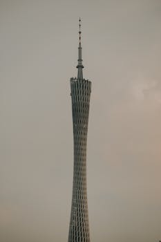 Dramatic shot of Canton Tower in Guangzhou with a moody sky backdrop, capturing modern architecture.