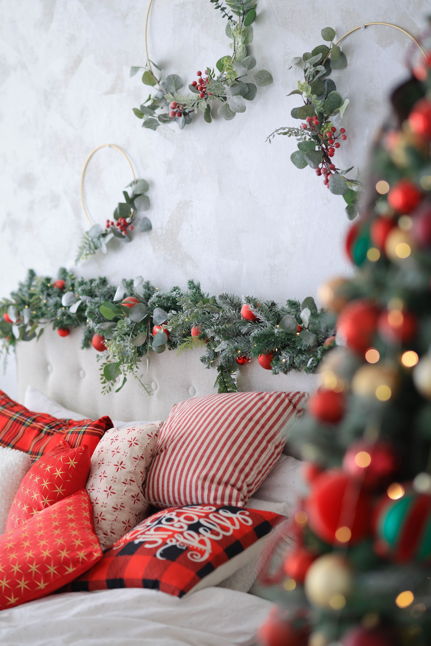 Christmas bedroom with red pillows tree lights and festive accents