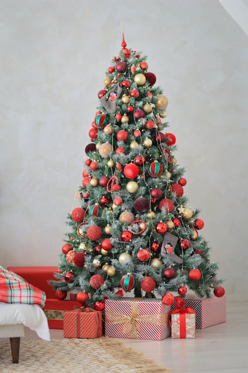 A Green Christmas Tree with Red Christmas Balls and Gifts