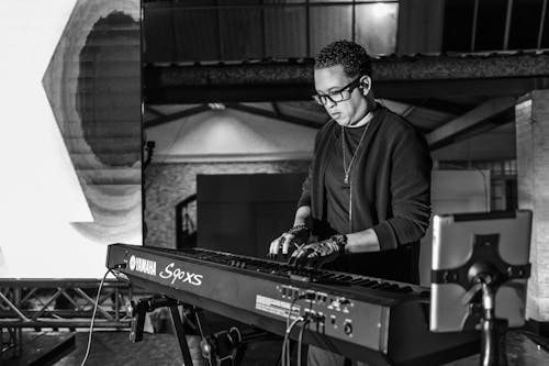 Grayscale Photo of a Man Playing Keyboard