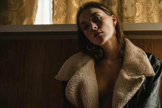 Artistic portrait of a woman in a shearling jacket, showcasing moody lighting.