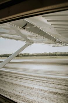 A view of the airplane wing and tarmac from inside the aircraft.