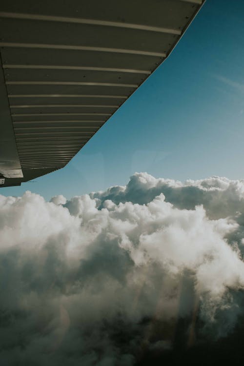 Free Clouds Below an Airplane Wing Stock Photo