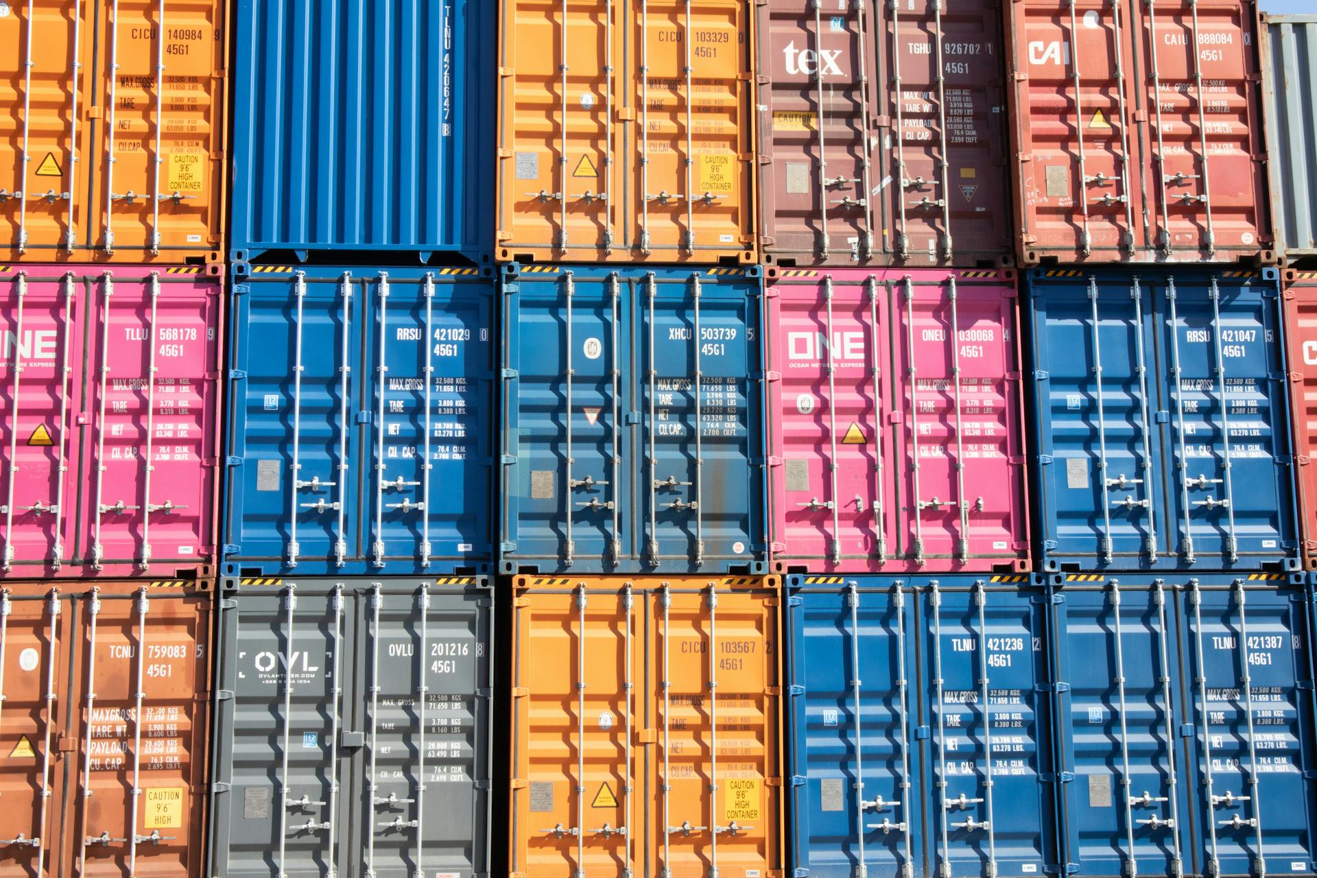 Stacked multicolored shipping containers at a Hamburg port, showcasing industrial logistics.
