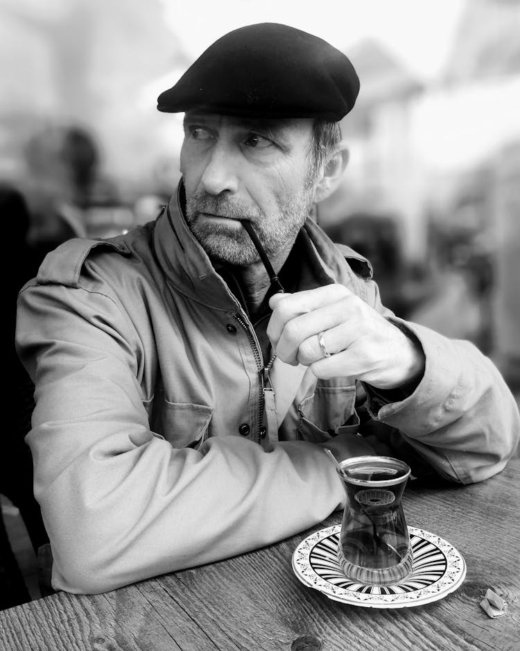 Man With Pipe And Coffee In Cafe