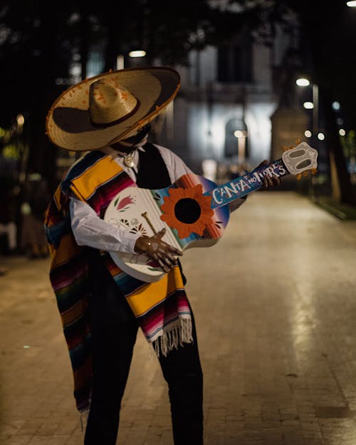 Man in Sombrero Playing Guitar at Night