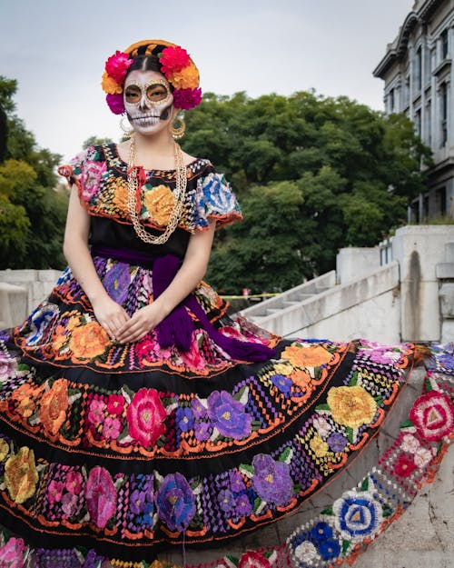 A Woman in Printed Dress with Painting on Her Face