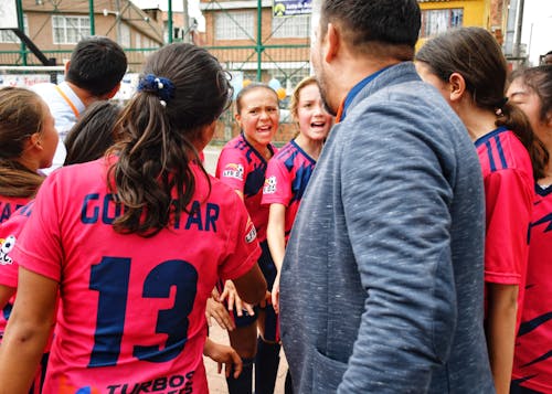 Free A vibrant moment capturing a youth soccer team in a motivational huddle with their coach, outdoors. Stock Photo