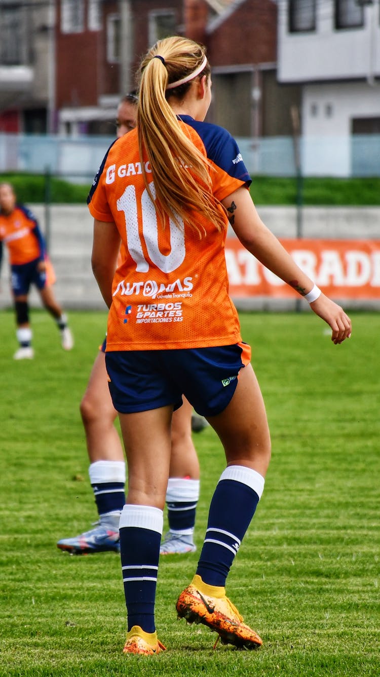 Girl In Uniform Playing Football On Field