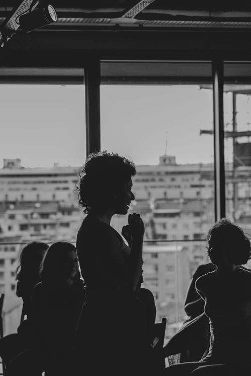 Free Black and white silhouette of people indoors against cityscape. Stock Photo