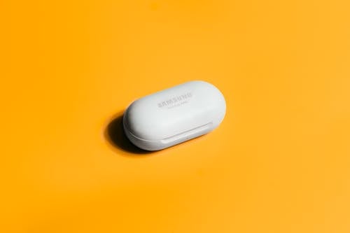 A Samsung Galaxy Buds on a Yellow Surface