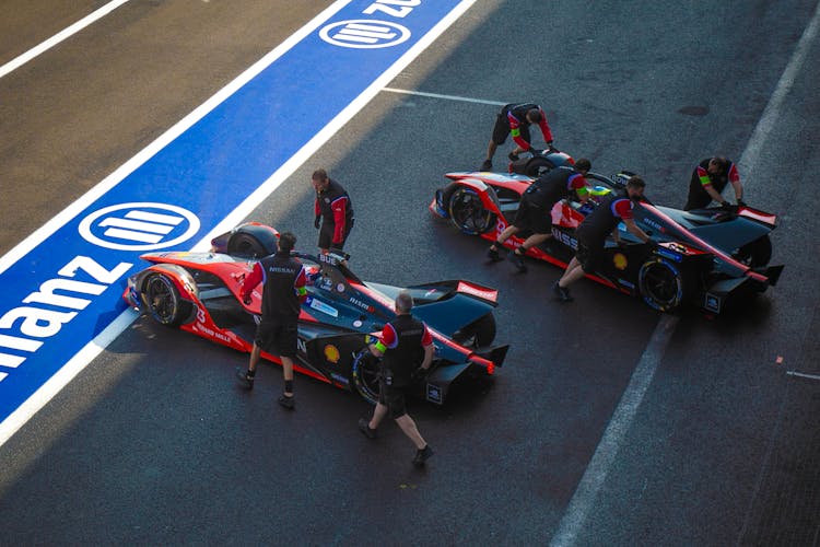 Pit Crew Pushing A Sports Car