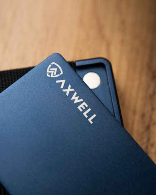 Free Blue Axwell wallet close-up on wood texture with visible text and magnetic clip. Stock Photo