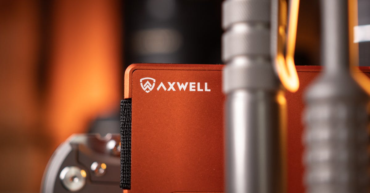 Detailed shot of an Axwell wallet with a flashlight and multitool on a wooden surface.