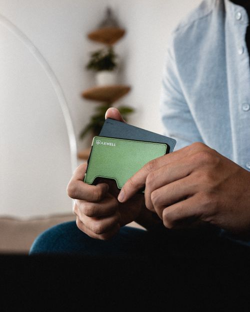 Free Close-up of a person holding a stylish green wallet indoors. Stock Photo