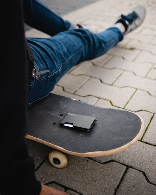 Close up of Man Sitting on Skateboard