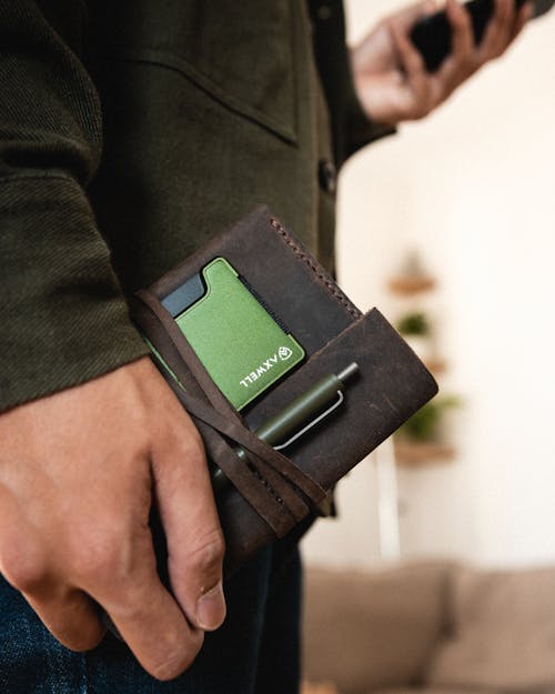 Man Hand Holding Bag with Pen and Wallet