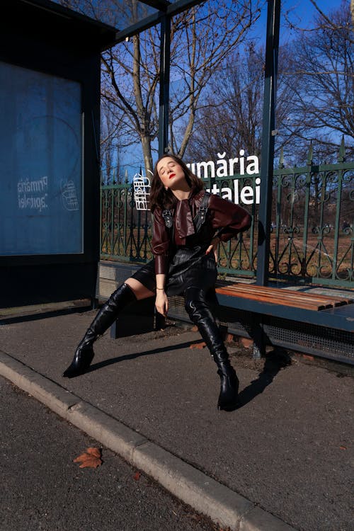 A Woman in Black Boots Sitting on the Bench