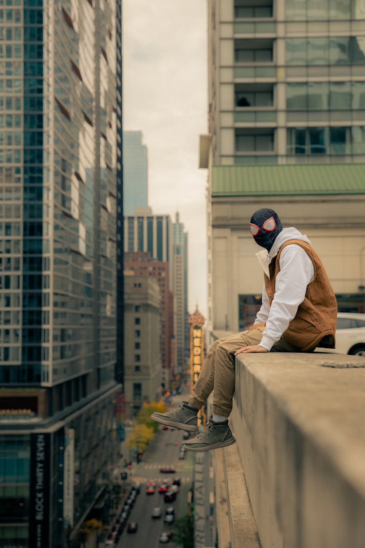 Man In A Mask Sitting On A Roof