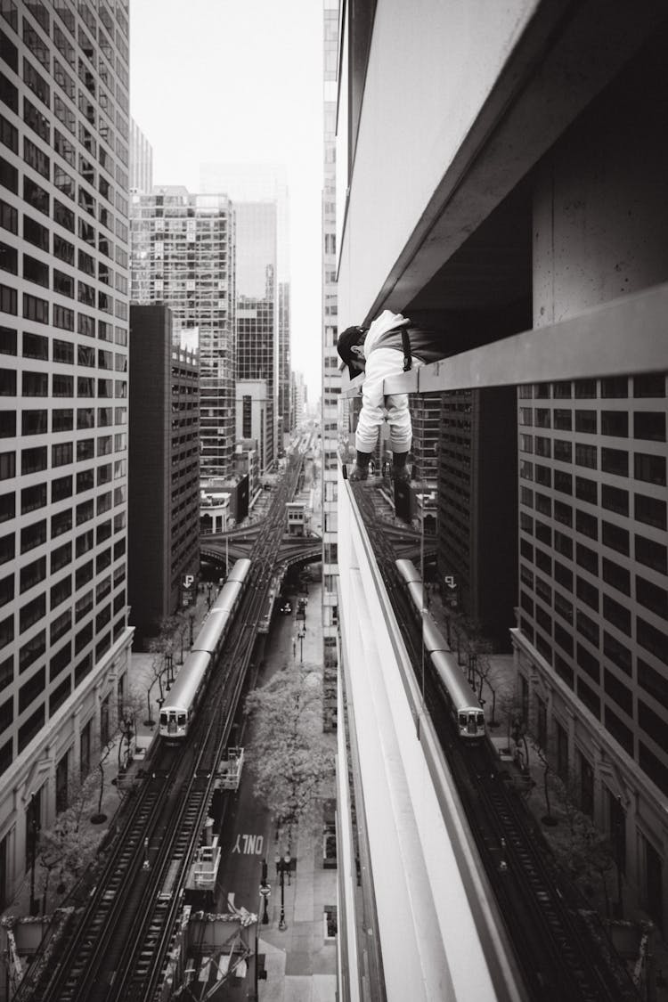 Man Hanging Out From A Balcony