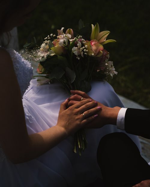 Free Close-up of a couple's hands and a bouquet, capturing a romantic wedding moment in Finnsnes, Norway. Stock Photo