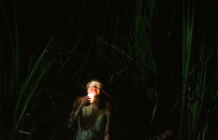 Woman With Candle And In Blindfold At Night