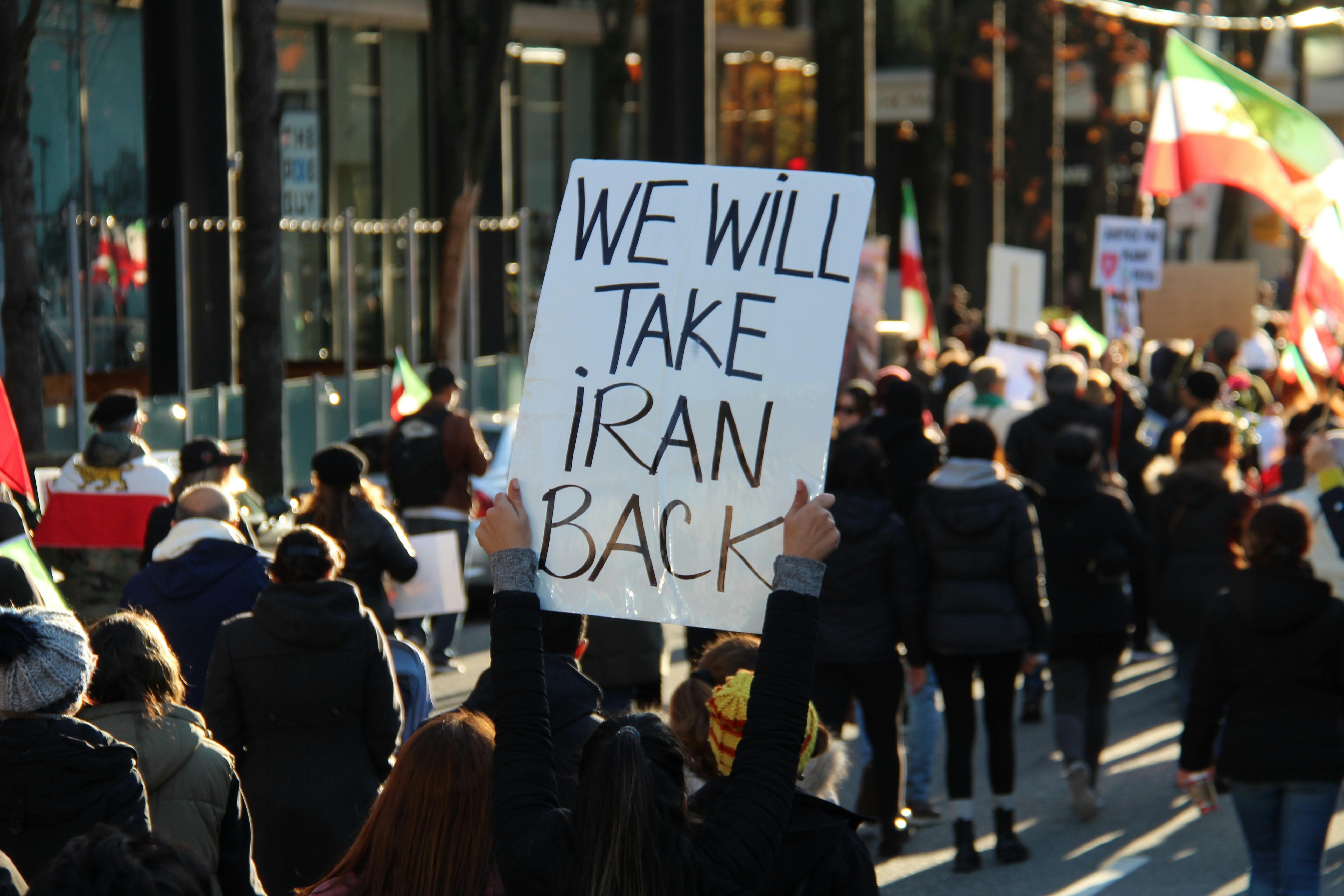 a person holding a placard with we will take iran back message in vancouver canada